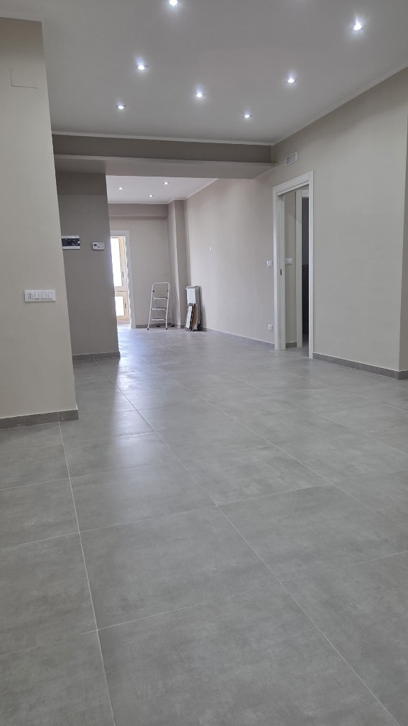 Ampio living con controsoffitto ribassato e faretti